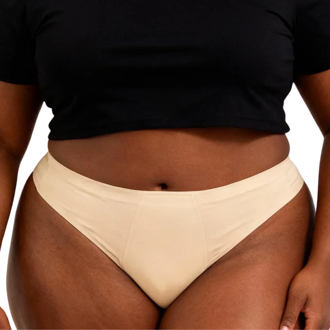 Woman wearing beige PFAS-free leak-proof period underwear, cropped black top